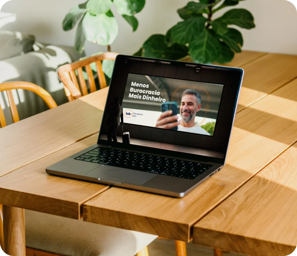 Laptop exibindo vídeo sobre menos burocracia e mais dinheiro.